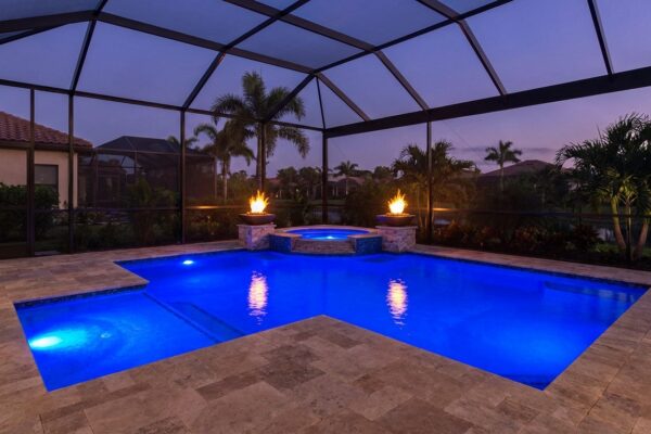 Custom pool with LED lights and fire bowls at twilight in Florida